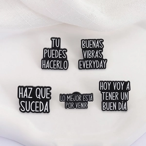 Set of 5 enamel pins with inspirational Spanish and English text on black metal badges