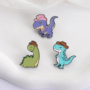 Tre spillette dinosauro cartone animato con cappelli da cowboy su vassoio bianco