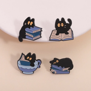 Set of four black cat enamel pins featuring books and tea cups for cat lovers