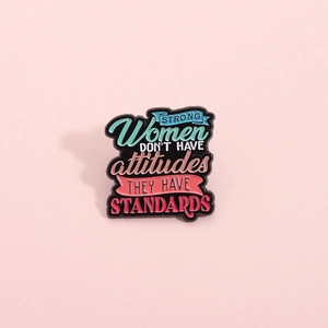Emaille-Brosche mit Strong Women Slogan auf rosa Hintergrund für Damenmode