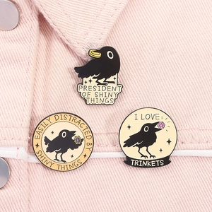 Close-up of enamel crow pins with witty quotes on a pink denim jacket detail