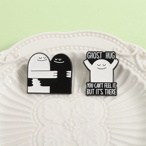 Emaille speldjesset Ghost Hug met zwart-witte cartoon badges op een bordje