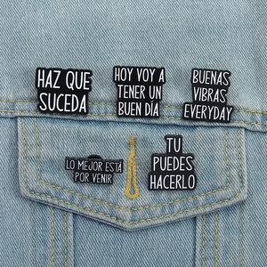 Set of 5 black enamel Spanish quote pins displayed on a blue denim jacket pocket