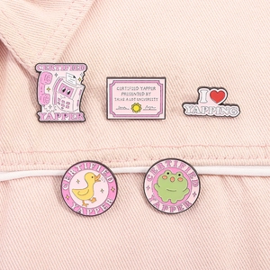 Lot de cinq pin's en émail rose avec citations amusantes sur fond en denim rose