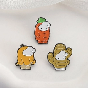 Detailed close-up of three cute rabbit enamel pins in fruit and vegetable outfits
