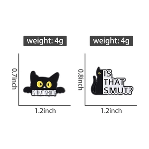 Detailed view of two black cat enamel pins showing precise size and weight measurements