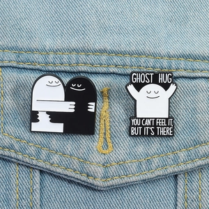 Schattige zwart-witte emaille pinnen en spookbadge op blauwe spijkerstof denim