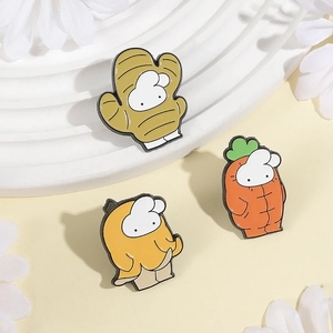 Three cute enamel pins featuring cartoon animals in vegetable outfits on a white stand