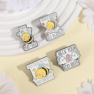 Set of 4 cute enamel bee pins with inspirational puns on a decorative white floral background