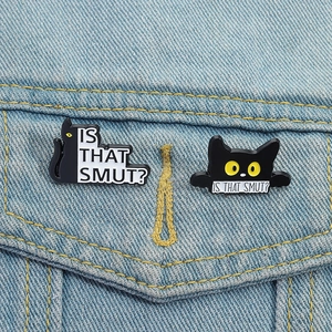 Set of two black enamel cat brooches with humorous text on denim fabric