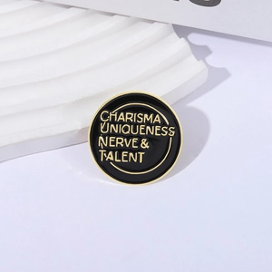 Minimalist enamel pin with gold 'Charisma Uniqueness Nerve & Talent' on round black base