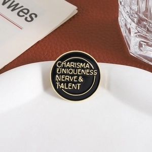 Charisma Uniqueness Nerve & Talent enamel pin badge in black and gold finish