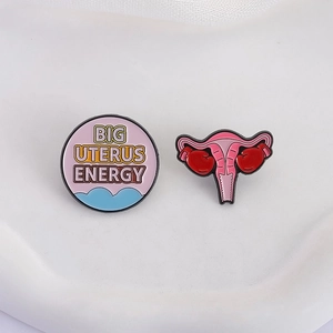 Feminist enamel pins set featuring Big Uterus Energy text and boxing gloves uterus design