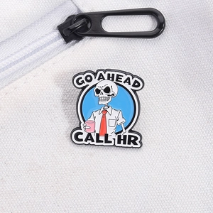 Detail of funny skeleton enamel pin with 'GO AHEAD CALL HR' text on canvas