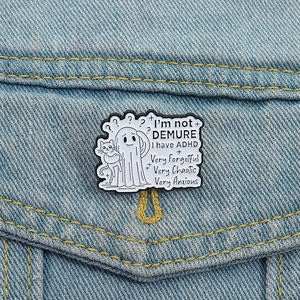 Ghost with cat enamel pin featuring ADHD descriptive text on denim jacket