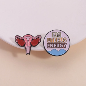Uterus design enamel pin set with Big Uterus Energy lettering and boxing glove motif