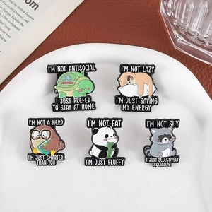 Five animal enamel pins including turtle and panda on a white plate and leather background