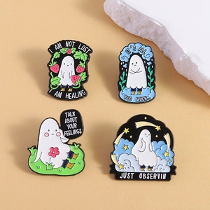 Set of four cute white ghost enamel pins with emotional text on a warm background