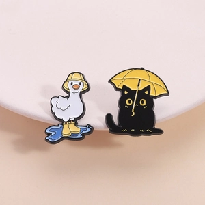 Pins en émail mignons avec un canard blanc en bottes et un chat noir avec un parapluie jaune