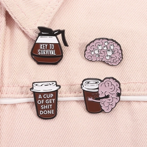 Détail de pins en émail café et cerveau sur denim rose avec texte créatif de survie