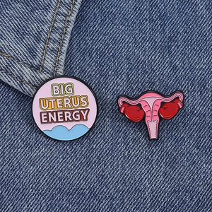 Creative Big Uterus Energy enamel pins with boxing gloves on blue denim fabric