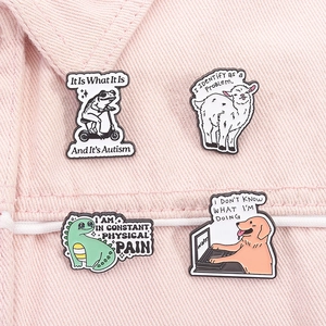 Détail de quatre épingles en émail d'animaux avec des phrases drôles sur denim rose