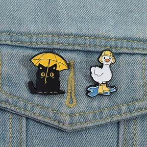 Cartoon animal enamel pin set featuring black cat with umbrella and duck in rain boots
