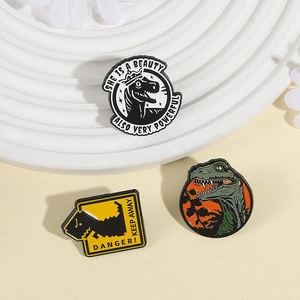 Three creative cartoon dinosaur enamel pins featuring T-Rex and warning sign designs