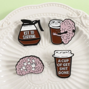 Lot de pin's en émail café et cerveau sur un plateau en céramique blanche décorative