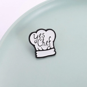 Creative chef hat enamel pin with Yes Chef lettering on a clean minimal background