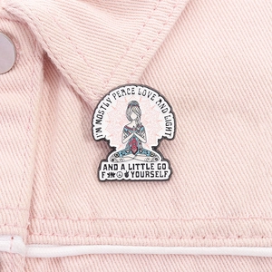 Detail of meditation enamel pin on pink denim with humorous yoga slogan and mandala art