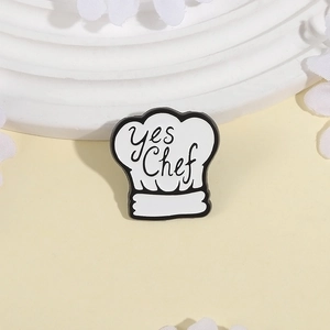 Cartoon chef hat enamel pin with Yes Chef lettering on a clean minimalist background