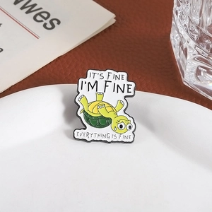 Funny green turtle enamel pin with 'IT'S FINE' slogan on white porcelain plate