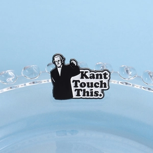 Detail of a black and white enamel pin featuring Immanuel Kant with humorous text