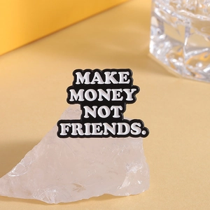 Détail du badge en émail avec citation Make Money Not Friends sur cristal