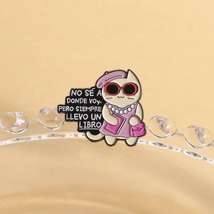 Dettaglio della spilla in smalto con gatto e citazione spagnola sui libri