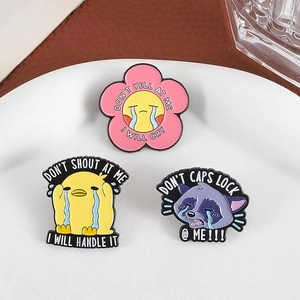 Three-piece set of cartoon enamel pins with duck and raccoon on a white plate