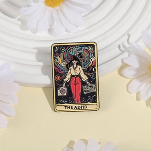 ADHD tarot style enamel brooch with vibrant illustration on a white decorative tray