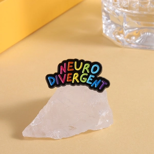 Detailed macro view of colorful Neurodivergent enamel pin on a white crystal stone