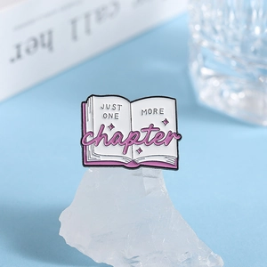 Pink open book enamel pin with Just One More Chapter text and star pattern engraving