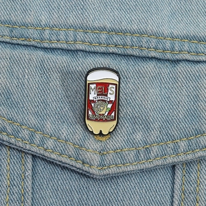 Creative enamel lemonade pin on blue denim jacket featuring vintage organic bottle design