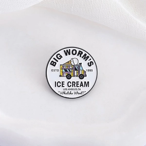 Detail of round enamel badge featuring a retro ice cream truck illustration and text