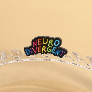 Close-up of a colorful rainbow enamel neurodivergent badge on a glass edge