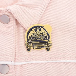 Detail der Vintage-Auto-Emaille-Anstecknadel auf pinkem Denim, schwarz und goldene Optik