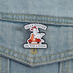 Cartoon enamel pin of a white goose riding a red scooter on denim jacket pocket