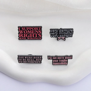 Set of four cute black enamel pins featuring pink feminist and social media slogan text