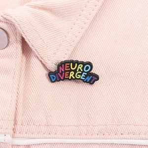 Macro shot of Neurodivergent enamel pin on pink denim jacket showing colorful lettering