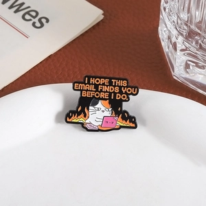 Close-up of a funny calico cat office pin with flames on a minimalist white ceramic tray