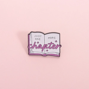 Cartoon book enamel pin with 'Just One More Chapter' text and star details