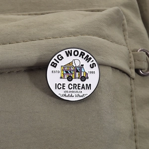 Detail of white enamel ice cream truck pin badge on green fabric with crisp metal edges